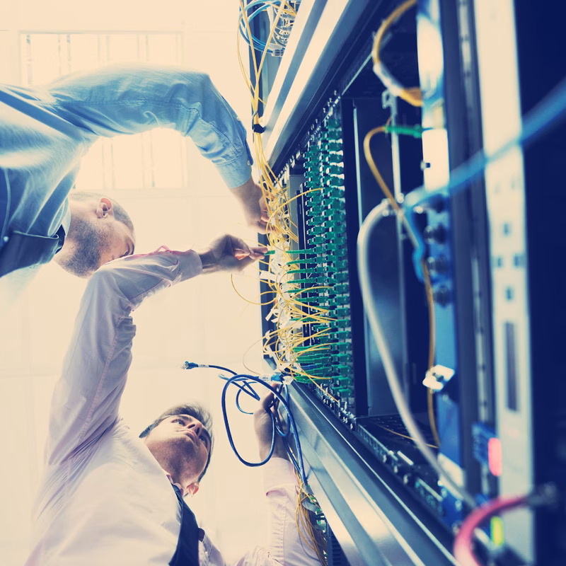 IT engineers managing equipment in a network server room